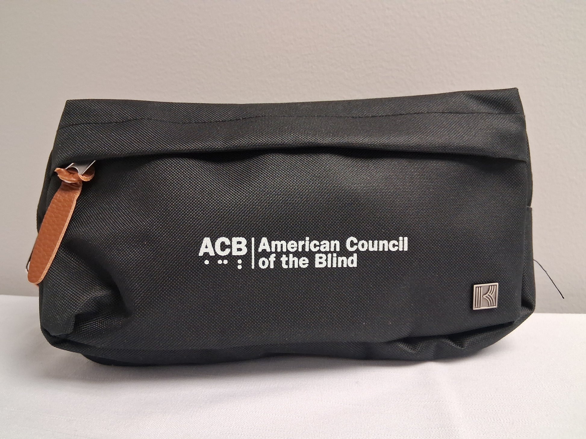 Black fanny pack with American Council of the Blind logo on a light gray background
