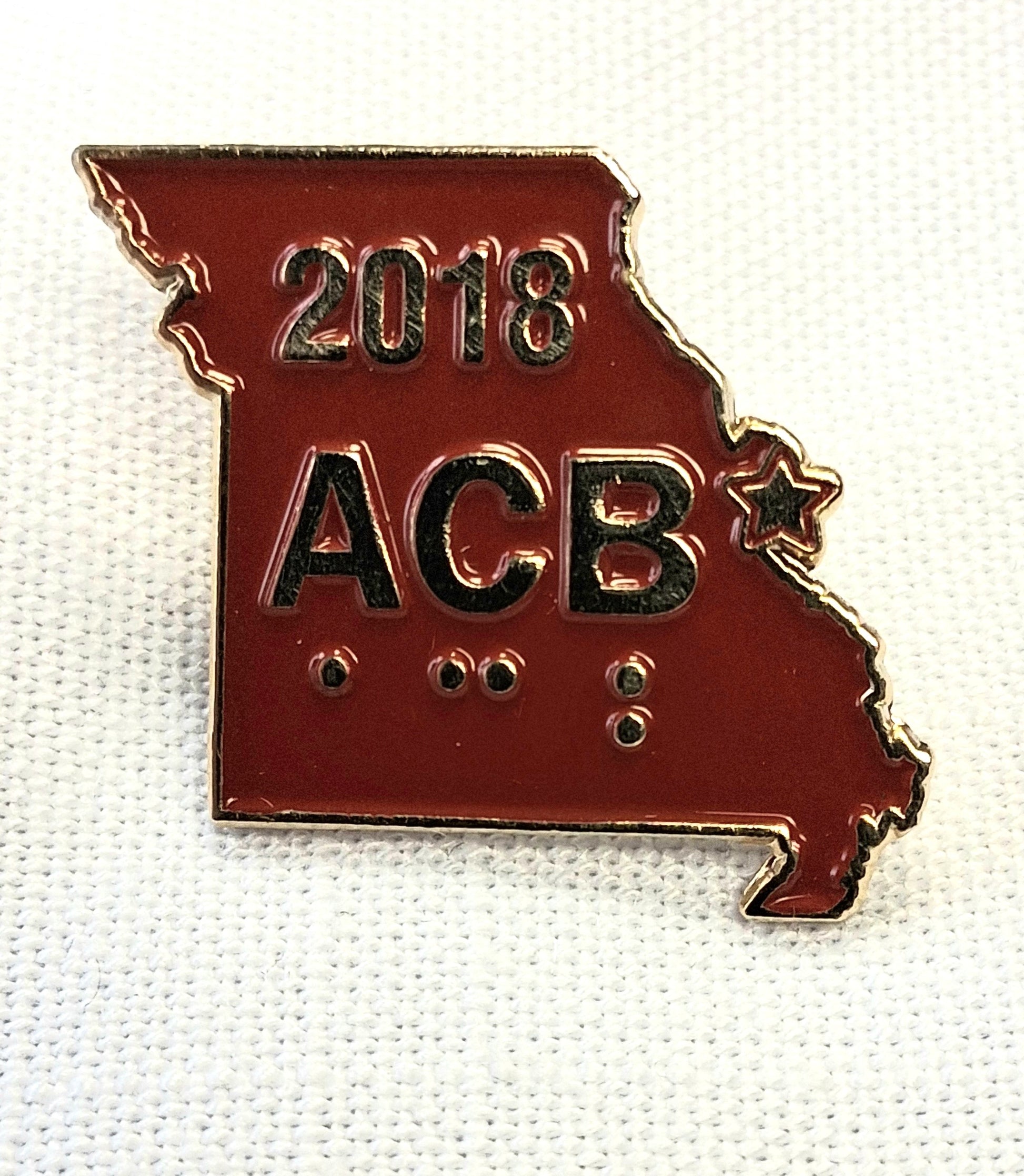 Pin with '2018 ACB' on a red background