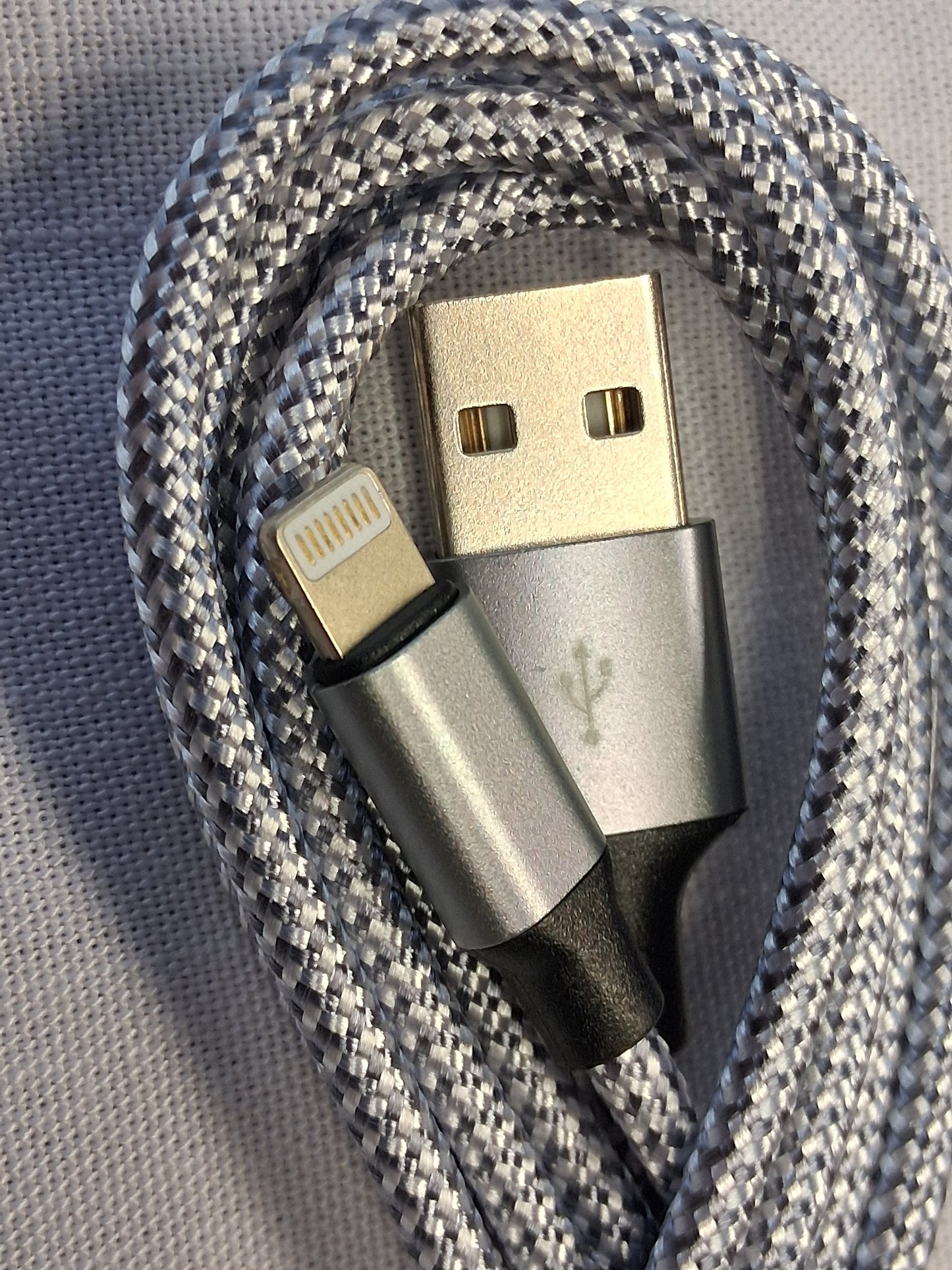 Multifunctional Apple cable with USB, lightning, and micro USB connectors on a textured gray background