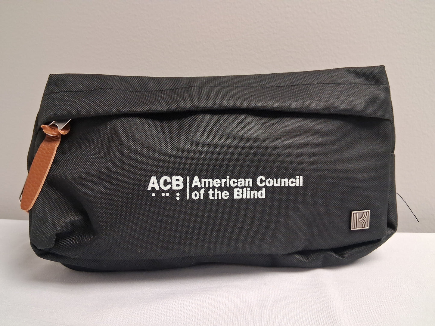 Black fanny pack with American Council of the Blind logo on a light gray background
