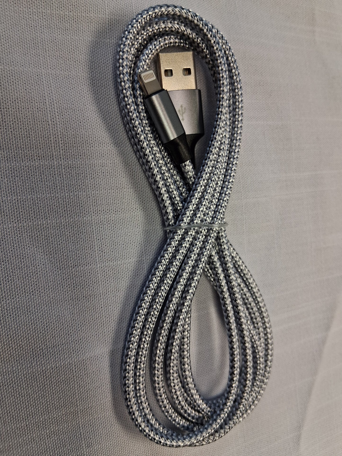 Coiled, Apple, USB cable on a gray textured surface
