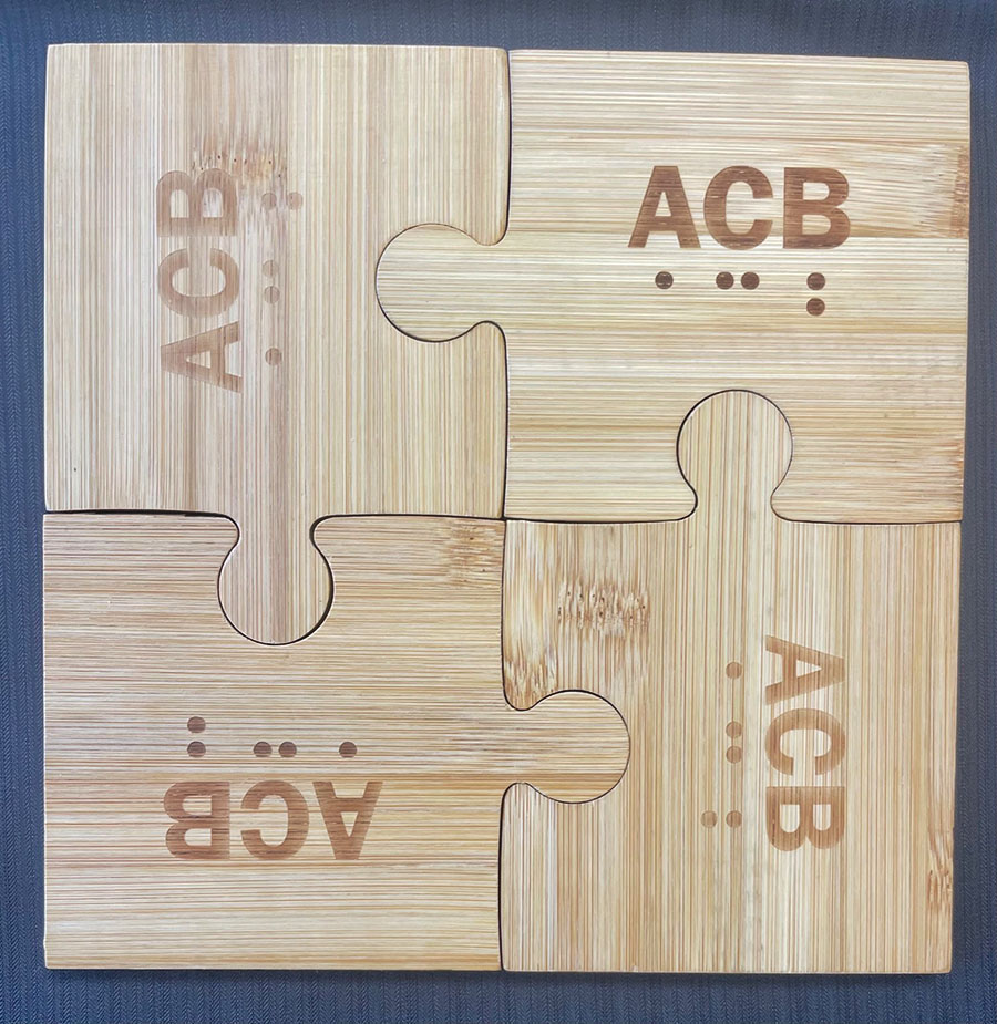Assembled bamboo puzzle coaster with ACB logo on each puzzle piece